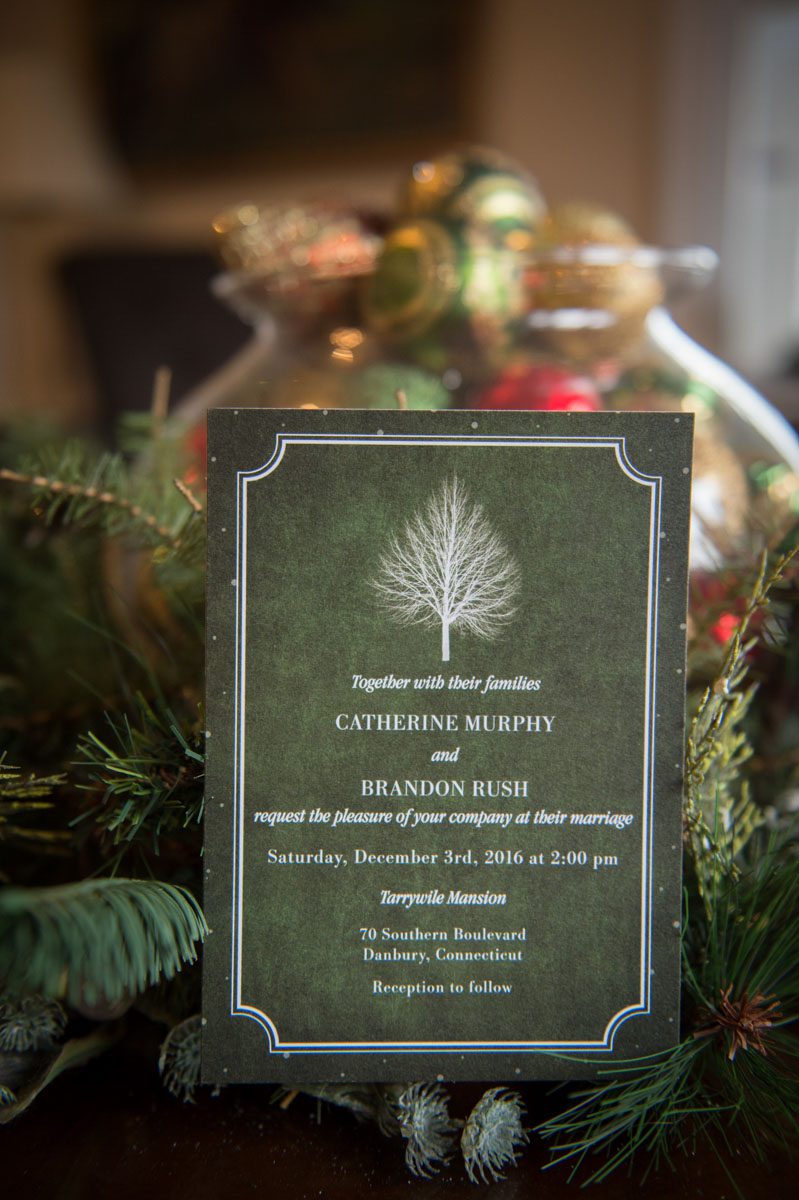 A December Wedding wedding invitation photographed in front of Christmas decorations