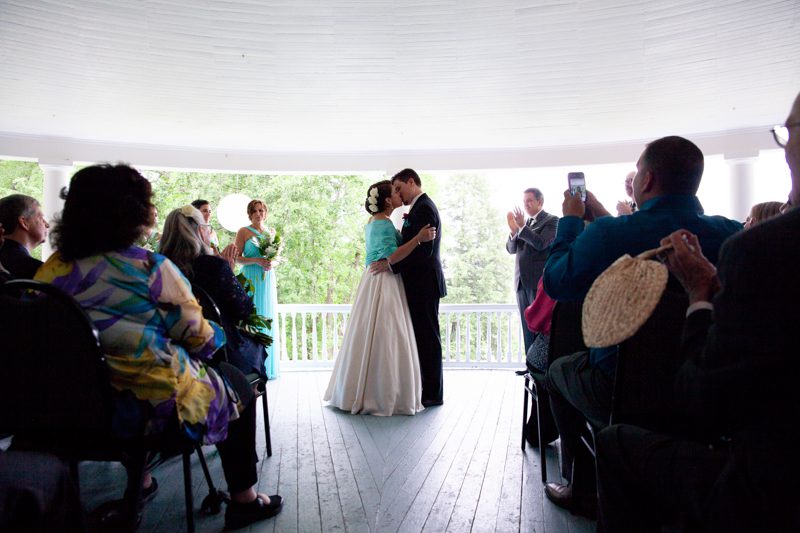 cuban-flair-wedding-newlywed-couple-share-their-first-kiss-on-veranda-in-front-of-guests